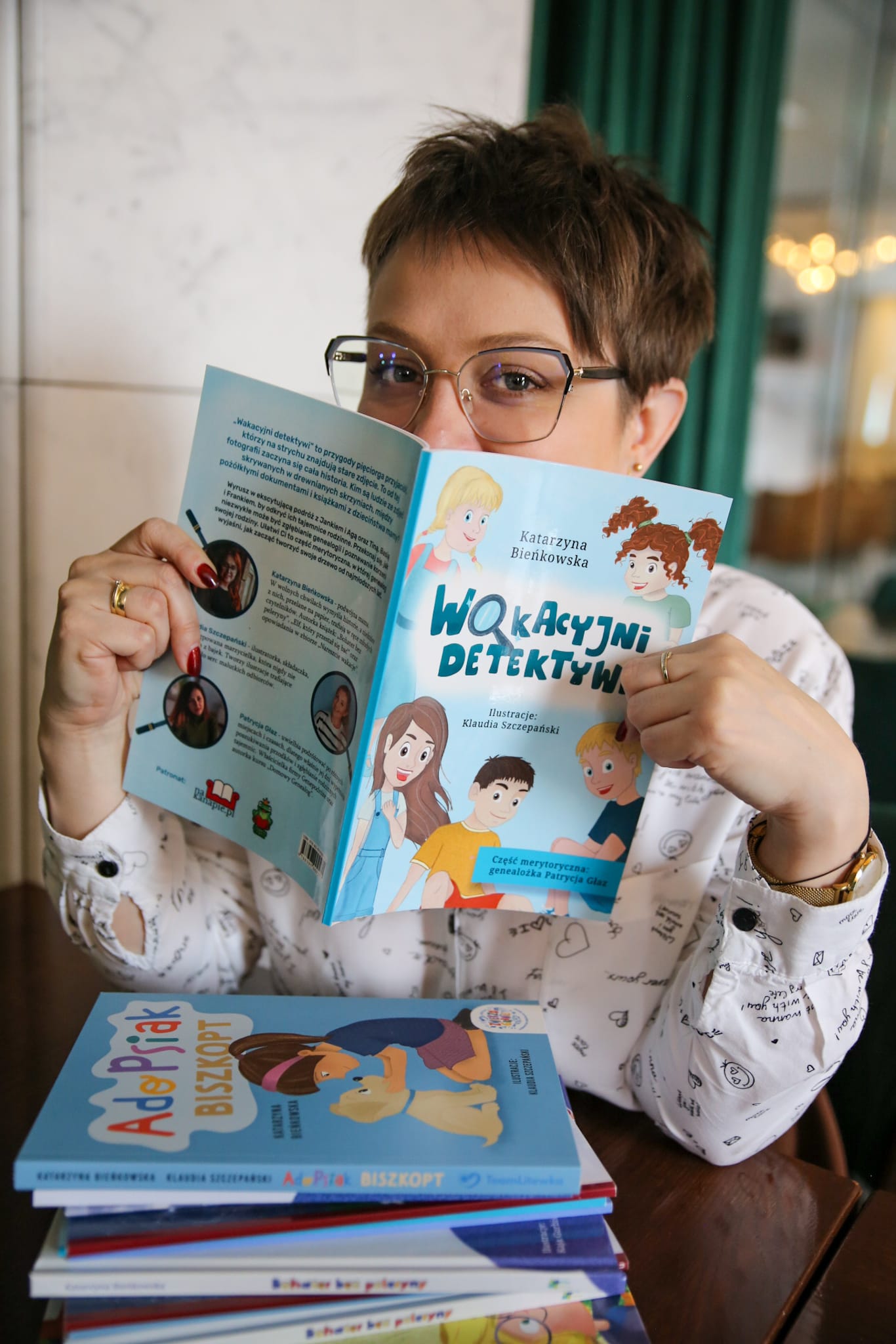 Katarzyna Bieńkowska prezentuje otwartą książkę Wakacyjni detektywi podczas spotkania z dziećmi